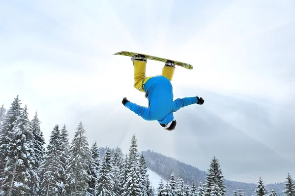 Snowboarder στο άλμα στα ψηλά βουνά την ηλιόλουστη μέρα — Φωτογραφία Αρχείου