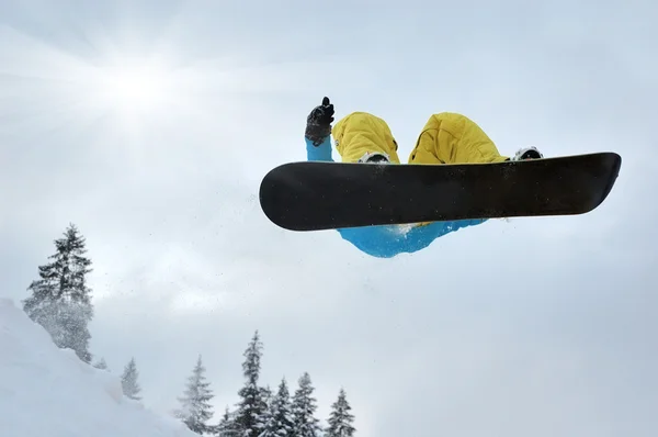 Snowboarder en salto inhigh montañas en día soleado —  Fotos de Stock