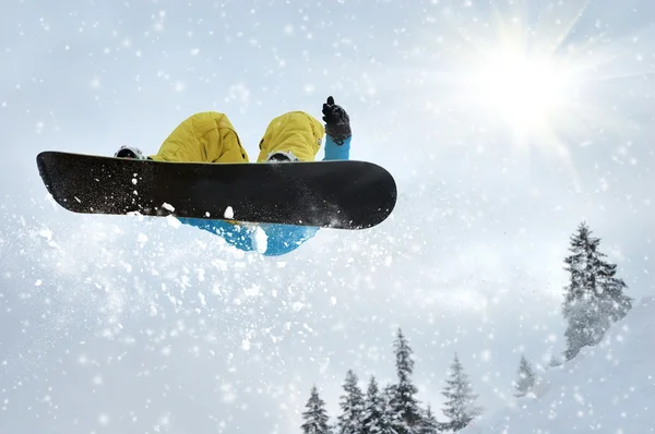 Snowboarder en salto inhigh montañas en día soleado — Foto de Stock