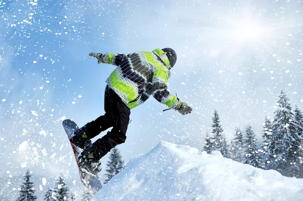 Snowboardzista podczas skoku w wysokie góry w słoneczny dzień — Zdjęcie stockowe