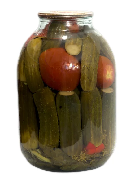 En un frasco de vidrio adobado pepinos y tomates en un respaldo blanco — Foto de Stock