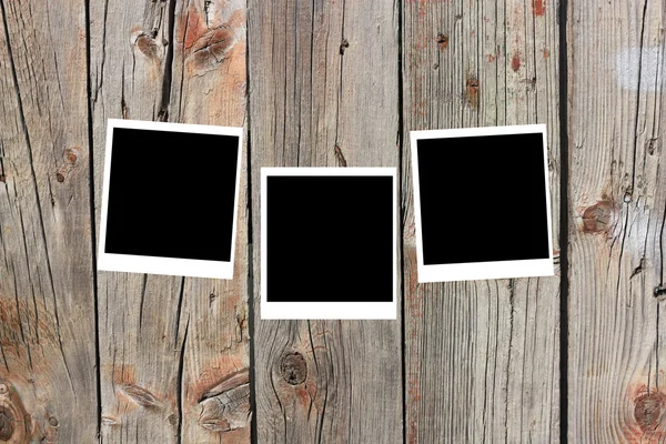 Conjunto de tres viejos marcos de polaroids en blanco que yacen sobre una superficie de madera —  Fotos de Stock