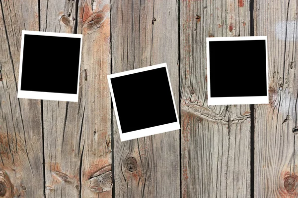Conjunto de três quadros antigos de polaróides em branco deitados sobre uma superfície de madeira — Fotografia de Stock