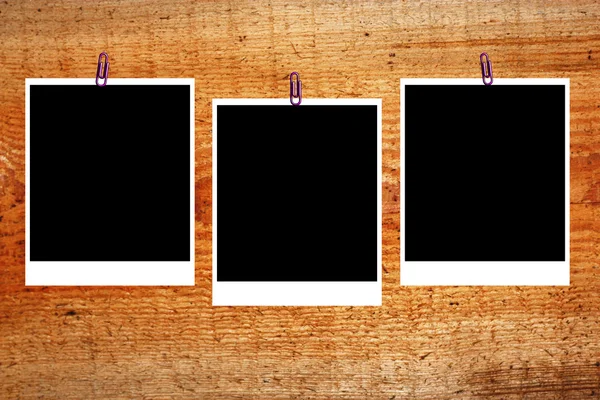 Uppsättning av tre gamla tomt polaroids ramar liggande på en trä yta — Stockfoto