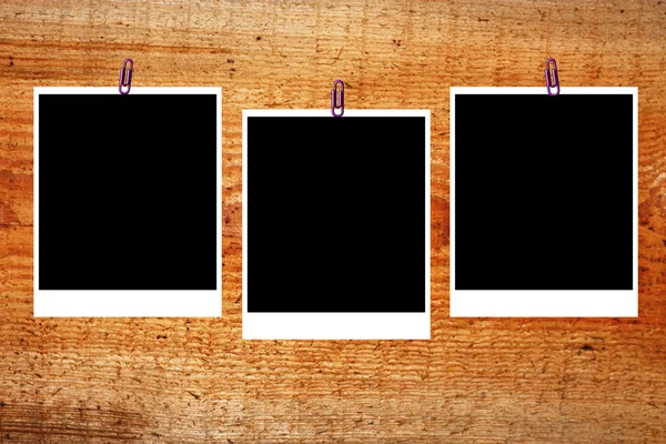 Set di tre vecchi telai di polaroid vuoti distesi su una superficie di legno — Foto Stock