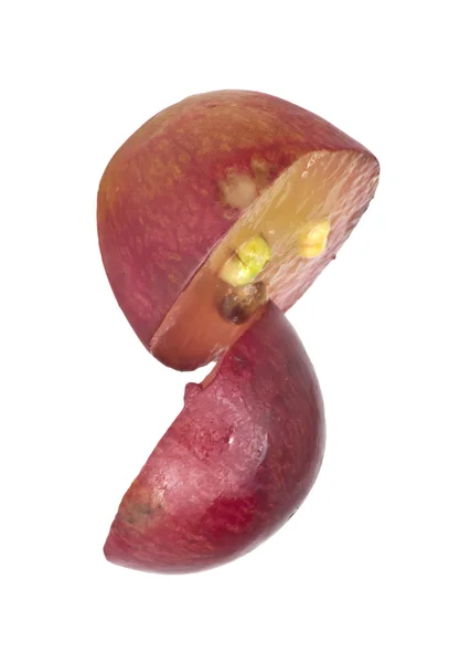 Rebanada translúcida de fruta de uva roja, macro aislada en blanco — Foto de Stock