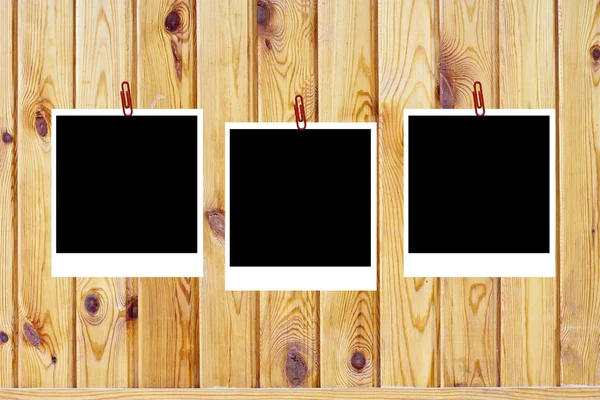 Uppsättning av tre gamla tomt polaroids ramar liggande på en trä yta — Stockfoto