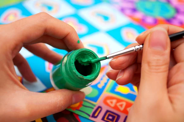 Händer med pensel och färg — Stockfoto