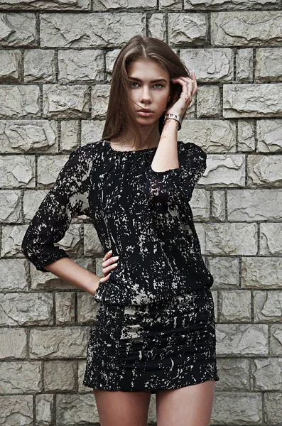 Hermosa mujer de moda contra una pared de piedra —  Fotos de Stock