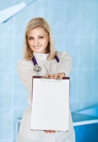 Sorridente giovane donna medico con lo stetoscopio e clipboa — Foto Stock
