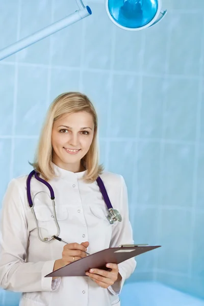 微笑年轻女医生用听诊器和 clipboa — 图库照片