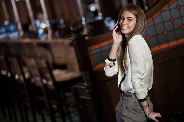 Wesoły młoda kobieta rozmowy na telefon komórkowy w wnętrza — Zdjęcie stockowe
