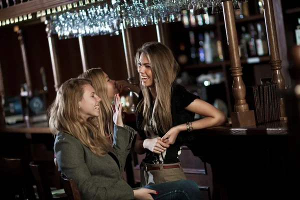 Tři šťastné ženy v nočním klubu sedí u baru — Stock fotografie