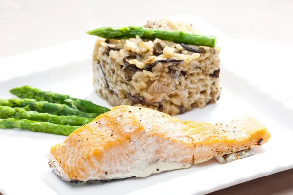 Baked salmon with mushroom risotto and green asparagus — Stock Photo, Image