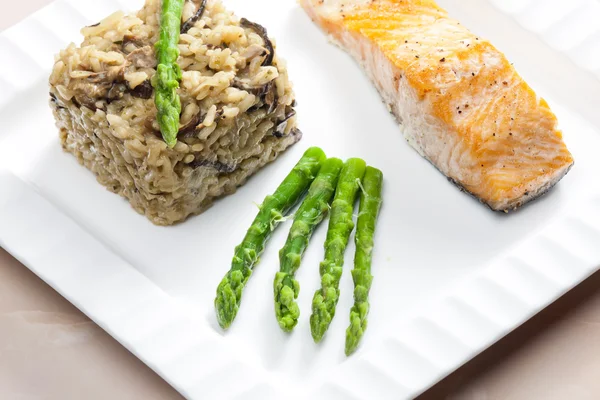 Baked salmon with mushroom risotto and green asparagus — Stock Photo, Image