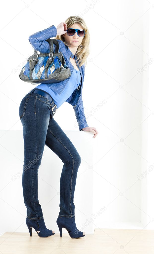 Standing woman wearing blue clothes with handbag