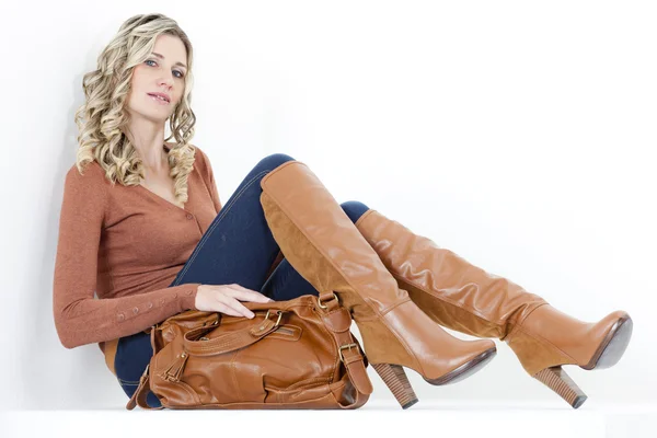 Donna che indossa stivali marroni alla moda con una borsa — Foto Stock