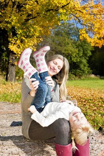 Mamma med sin lilla dotter i höstliga naturen — Stockfoto
