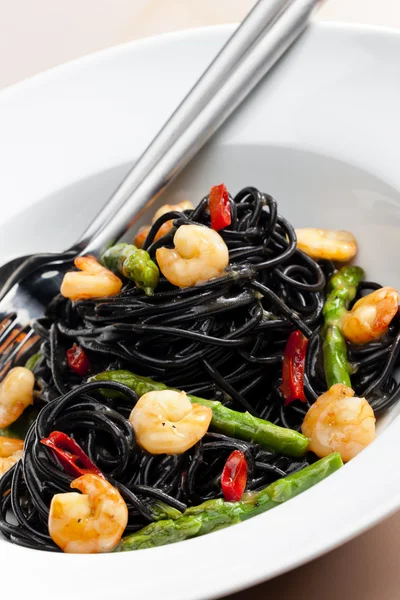 Sepia spaghetti with prawns — Stock Photo, Image