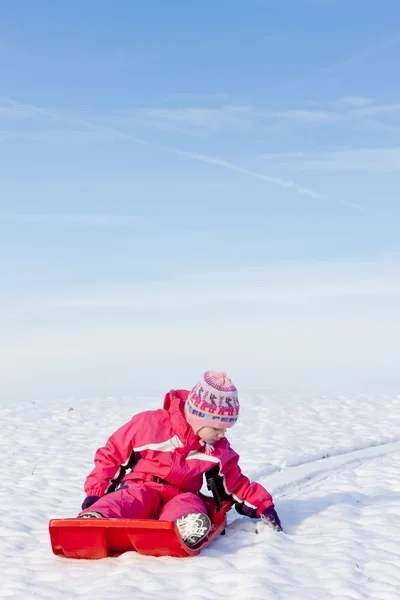 Liten flicka med bob i snö — Stockfoto