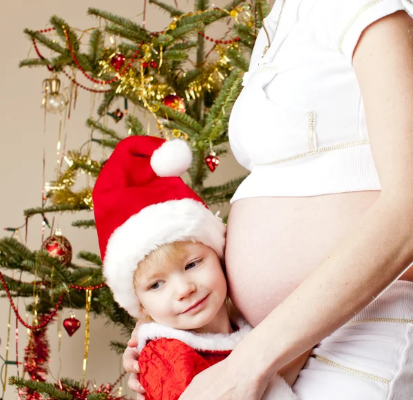 Klein meisje en haar zwangere moeder met Kerstmis — Stockfoto