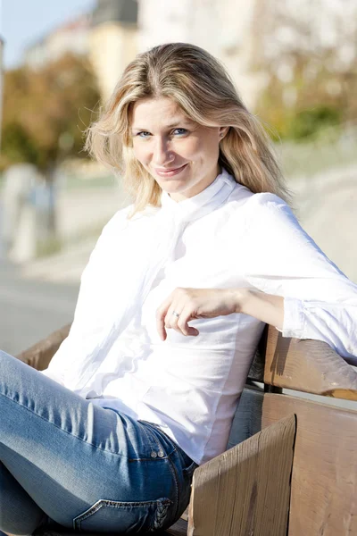 Portrét ženy sedí na lavičce — Stock fotografie