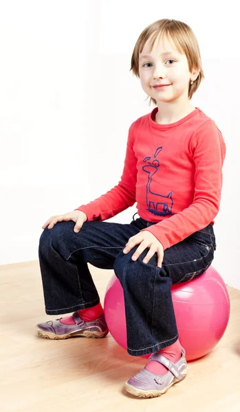 Девушка сидит на мяче — стоковое фото