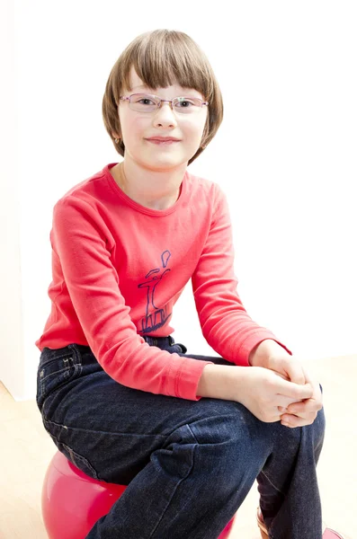Topun üzerinde oturan bir kızın portresi — Stok fotoğraf