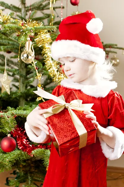 Kleines Mädchen als Weihnachtsmann mit Weihnachtsgeschenk — Stockfoto