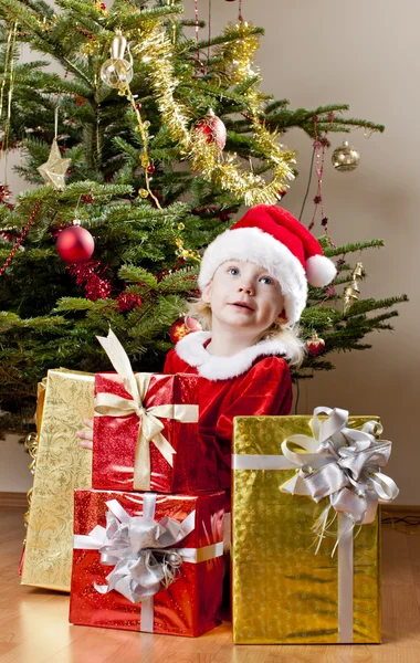 Holčička jako santa claus s vánoční dárky — Stock fotografie