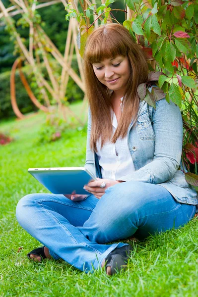Молода жінка читає в планшетному ПК — стокове фото