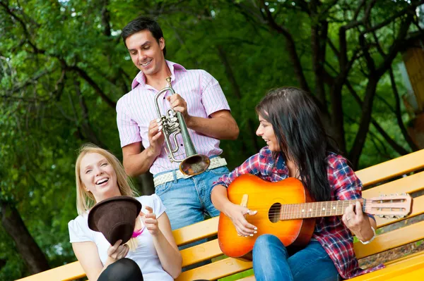 Jovens amigos tocam violão e trompete — Fotografia de Stock