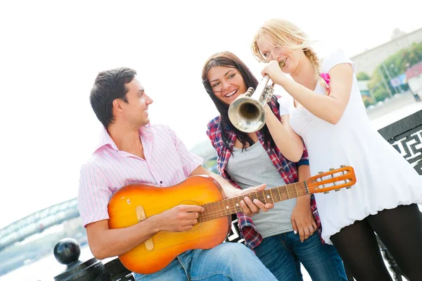 Молодые друзья играют на гитаре и трубе — стоковое фото