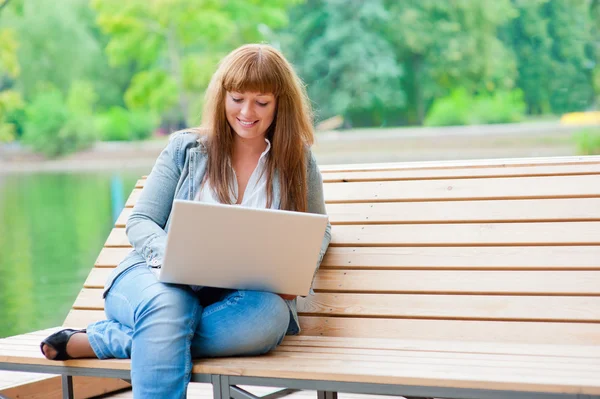 Jonge vrouw werkt op laptop — Stockfoto