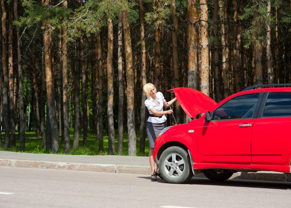Blond och trasiga bil — Stockfoto