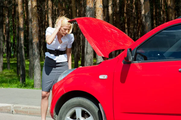 Blondynka i uszkodzony samochód — Zdjęcie stockowe