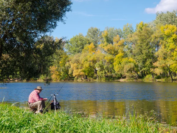 stock image Senior fisherman catches a fish