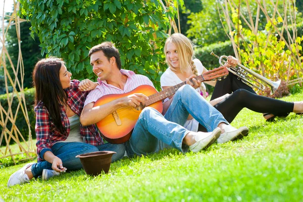 Giovani amici suonano la chitarra e la tromba — Foto Stock