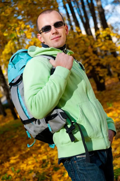 Glücklicher junger Mann mit Rucksack im Park. — Stockfoto