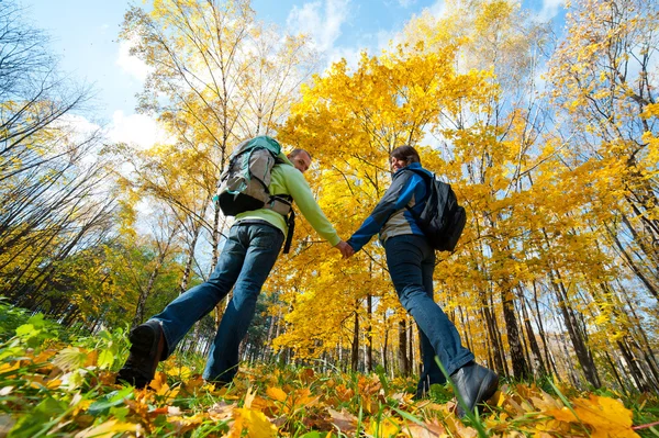 Glada unga par med ryggsäckar i parken — Stockfoto