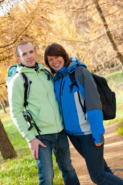 Glückliches junges Paar mit Rucksäcken im Park — Stockfoto
