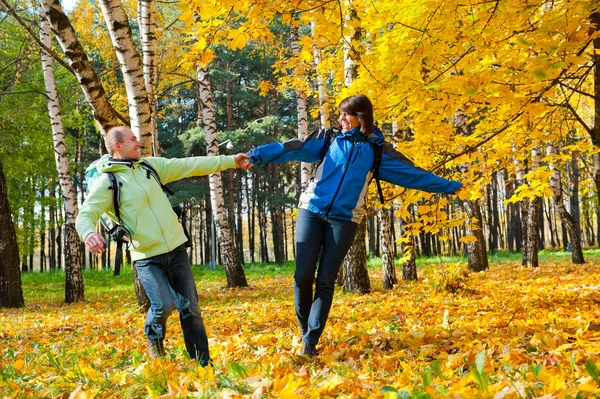 Šťastný mladý pár s batohy v parku — Stock fotografie