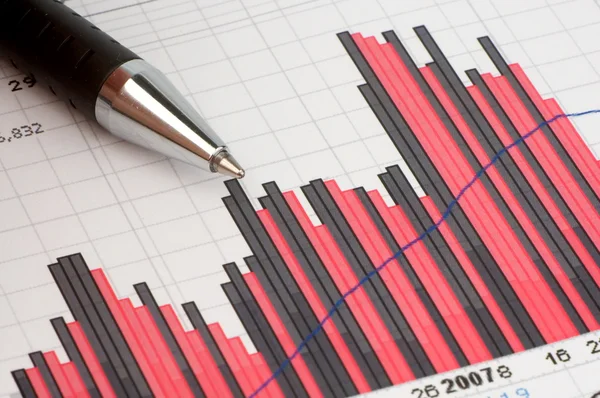 Ручка, показывающая диаграмму финансового отчета или журнала — стоковое фото