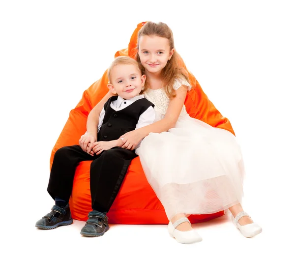 Broer en zus zittend op een stoel — Stockfoto
