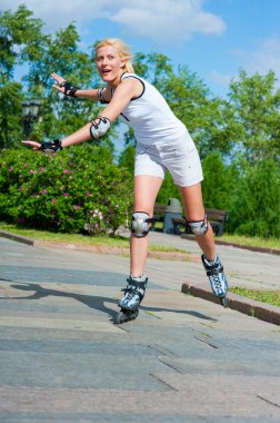 Girl roller-skating in the park clipart