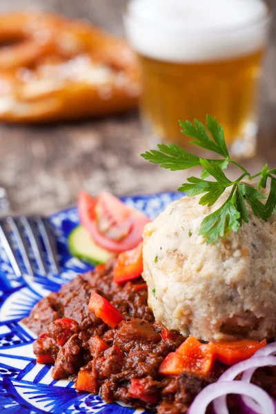 stock image Goulash with dumpling on a blue plate