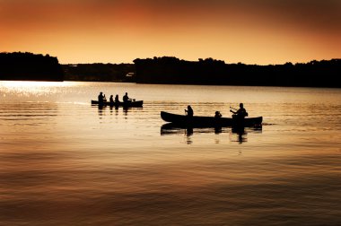 Göl kenarında canoers silueti