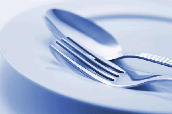 Forchetta e cucchiaio su piatto — Foto Stock