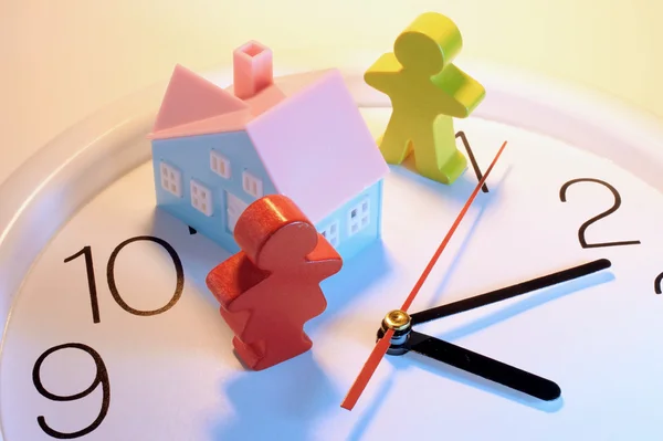 Träfigurer och toy house på klocka — Stockfoto