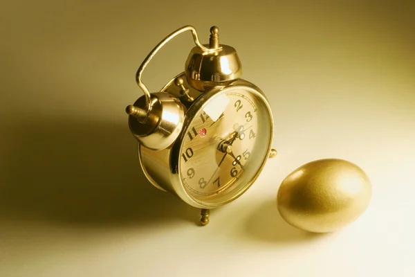 Altın yumurta ve çalar saat — Stok fotoğraf